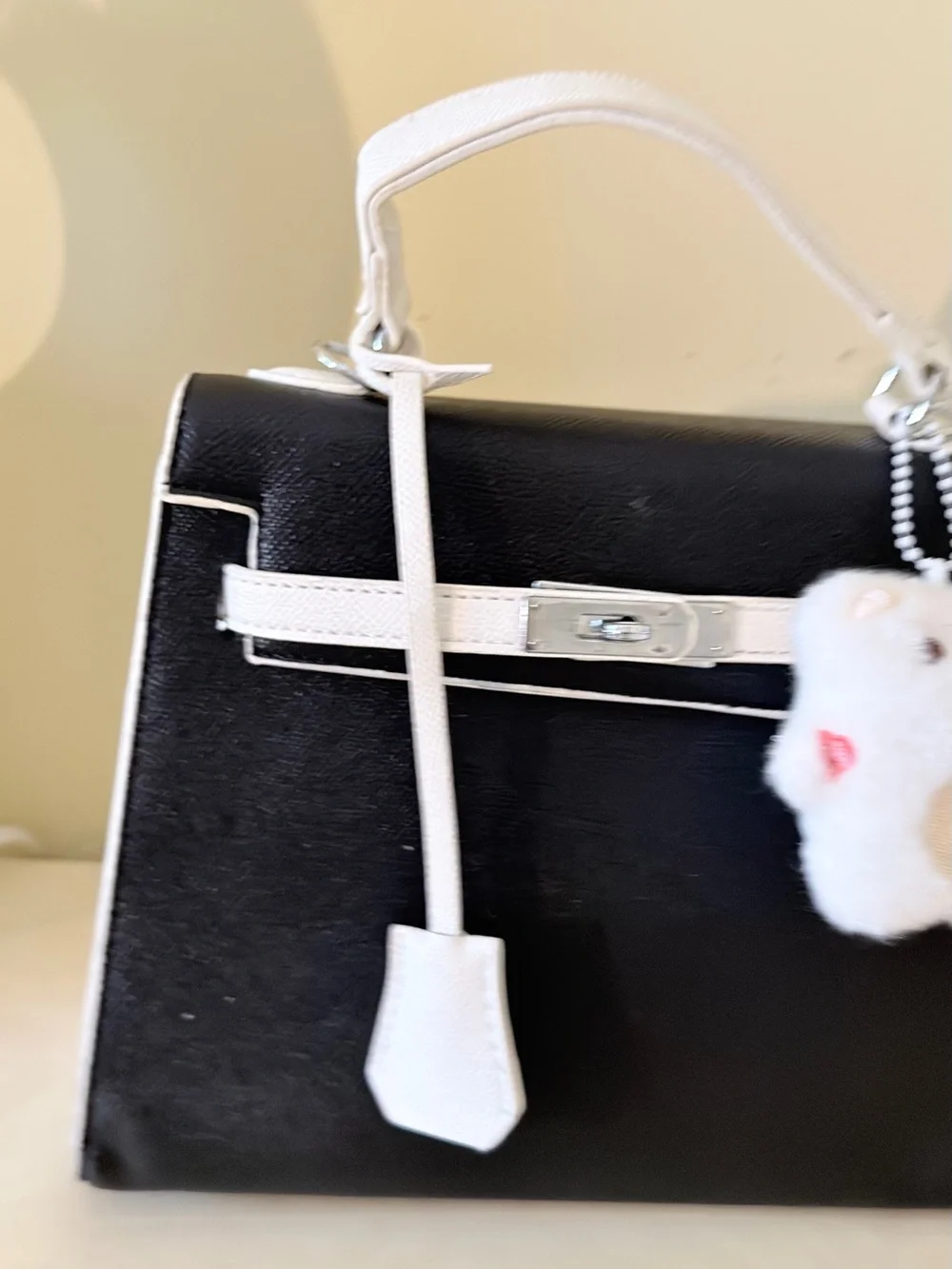Black and White Structured Top-Handle Bag with Plush Charm